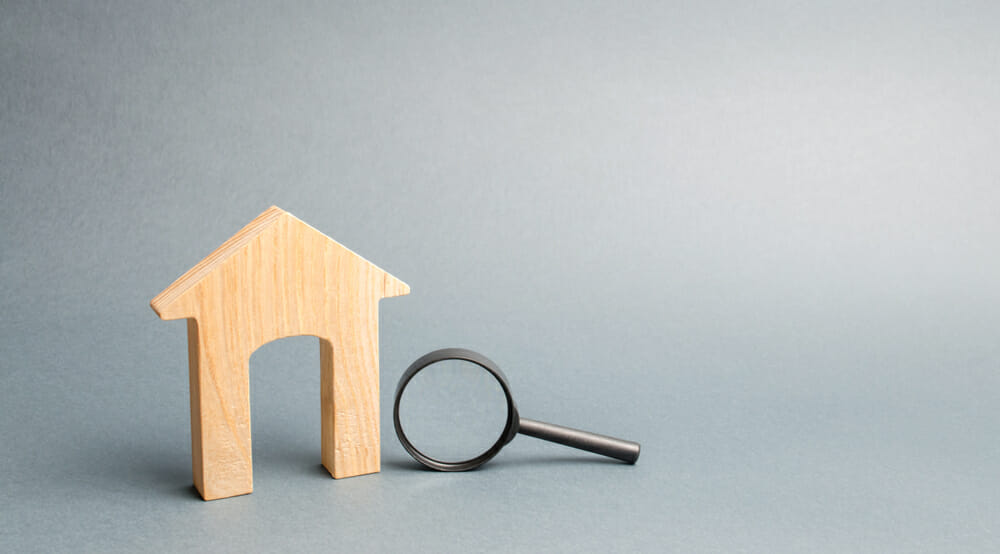 wood house and magnifying glass