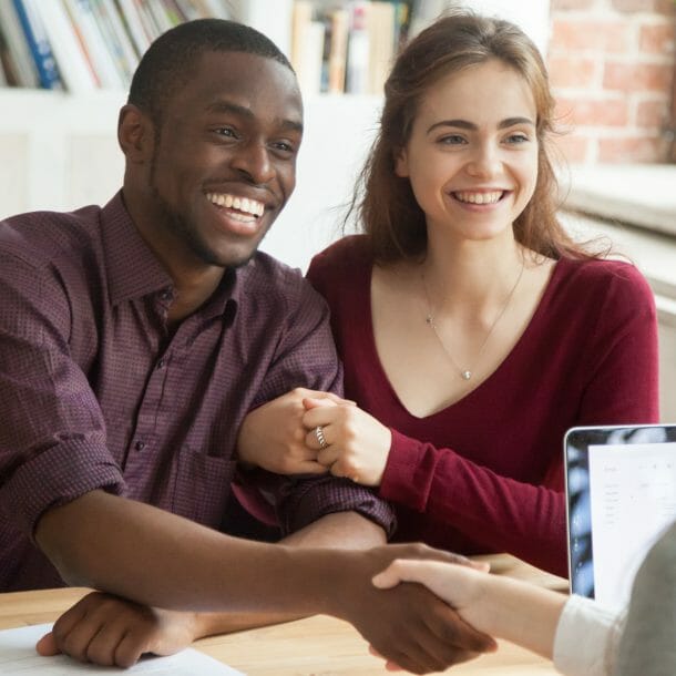 Cute couple shaking hands with appraiser