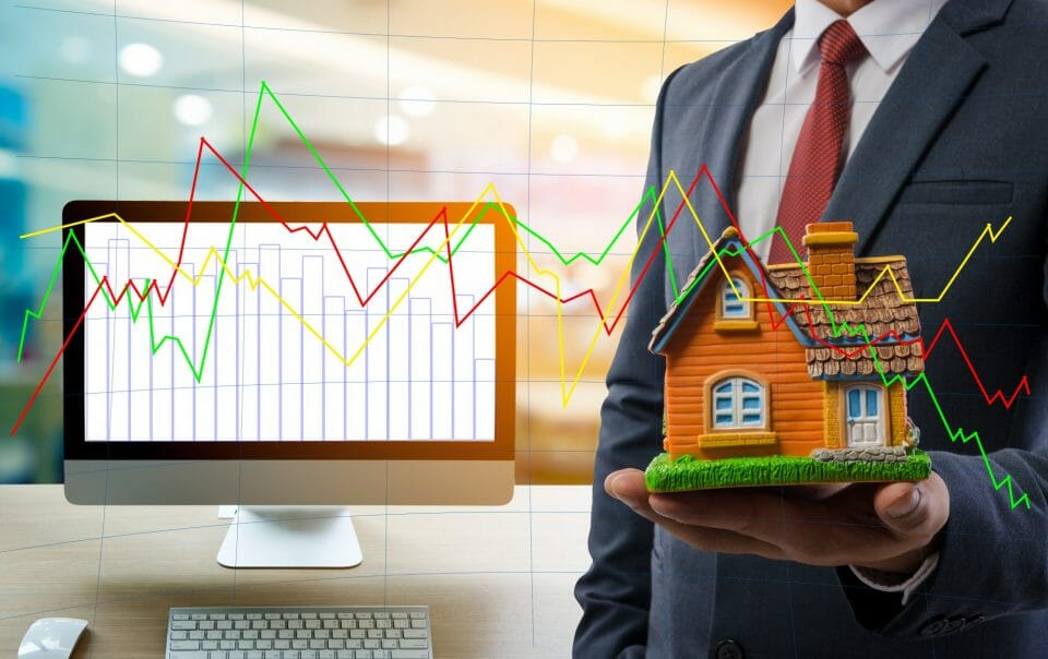 Stats and man holding model of house